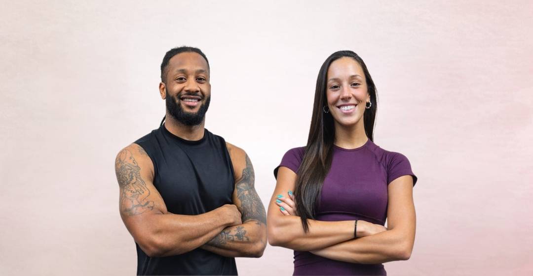 Milton Cabral e Madalena Almeida, treinadores do AlmaFit Studio, de braços cruzados e a sorrir.